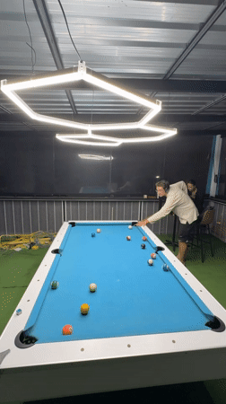Man plays pool game at indoor venue in Thailand