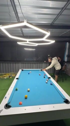 Man plays pool game at indoor venue in Thailand