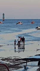 Low tide beach scene with traditional boats in Denpasar
