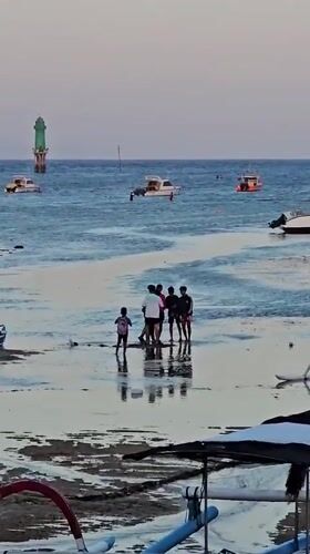 Low tide beach scene with traditional boats in Denpasar