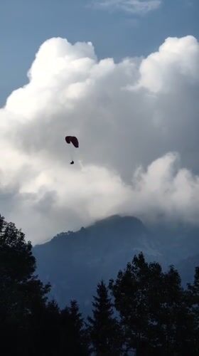Paragliding over Solang Valley on a clear mountain afternoon