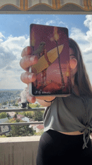Woman displays tarot card on balcony in Waiblingen