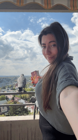 Woman displays tarot card on balcony in Waiblingen