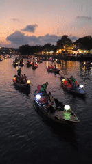 Tourists explore illuminated Hoi An waterfront and ancient town streets