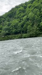 Person observed on bridge over turbulent river in Bzypta