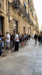 Barcelona street scenes show retail queue, pedestrians near historic buildings