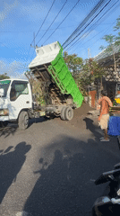 Dump truck unloads soil on street in North Kuta