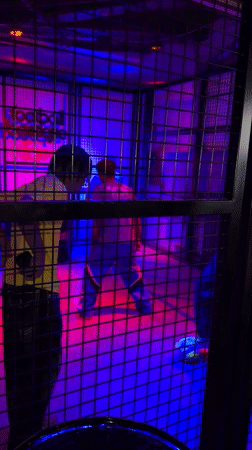 Neon-lit cage structure with occupants observed in Los Angeles