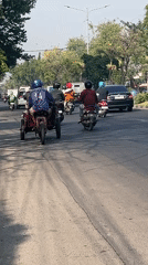 Morning traffic and roadside life along a busy Gelam street