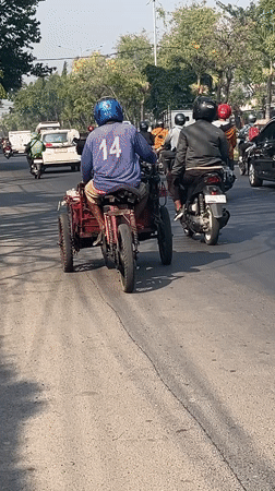 Morning traffic and roadside life along a busy Gelam street