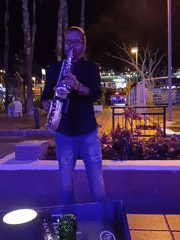 Saxophonist performs near busy restaurant in Gran Canaria evening