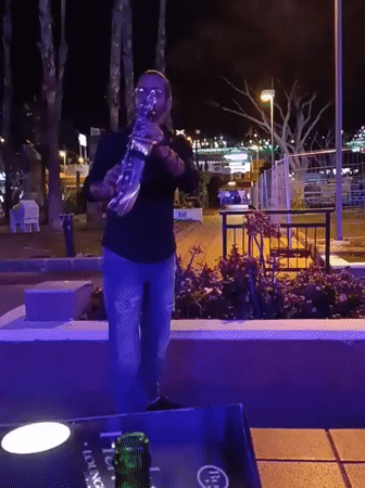 Saxophonist performs near busy restaurant in Gran Canaria evening