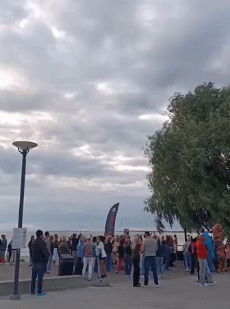 Crowd gathers along Tallinn's waterfront on a cloudy evening