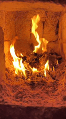 Fire burning in kiln with glowing wood fuel