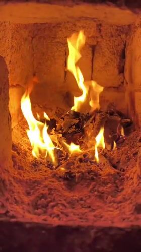 Fire burning in kiln with glowing wood fuel