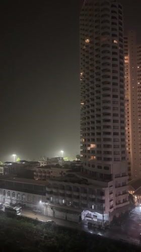 Heavy rain batters illuminated Pattaya towers during evening storm