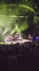 Live band performs under green lights for a crowd in Raanana