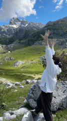 Woman celebrates scenic mountain views in Brskut, Montenegro