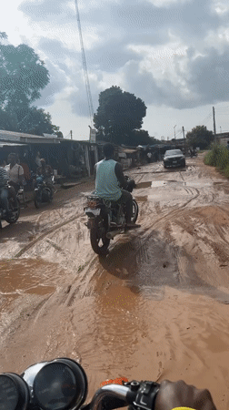 Motorcycles navigate muddy roads in Ihiagwa, Nigeria delivery scene