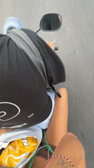 Two people ride scooter in Kuta Selatan, Indonesia