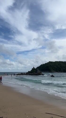 Beach activities continue under cloudy skies in Rawai, Thailand