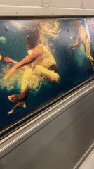London display case shows underwater performers juggling colored balls