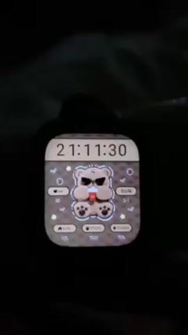 The video shows a smartwatch screen in the dark. The watch face features a cartoon teddy bear wearing sunglasses and holding a drink. The time is displayed as 21:11:30. Other information on the screen includes heart rate (HR) at 80, the date as Sun 3-1, calories burned at 125, steps taken at 1522, and power at 75%. Small star graphics are scattered around the screen. The watch's case appears black.