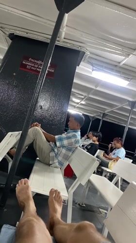 Ferry passenger relaxes during evening journey near Nathon, Thailand