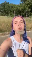 Woman with purple hair enjoys spring afternoon in French countryside