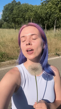 Woman with purple hair enjoys spring afternoon in French countryside