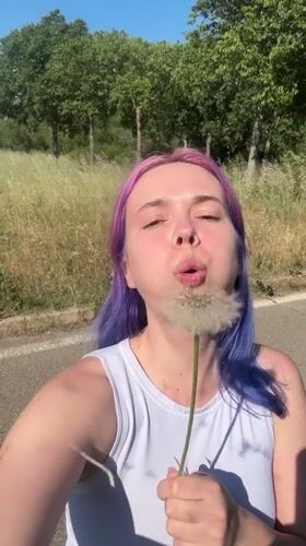 Woman with purple hair enjoys spring afternoon in French countryside