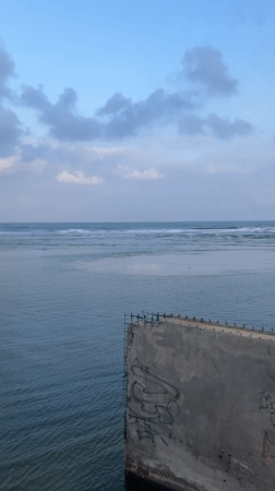 Tel Aviv waterfront: graffiti seawall, beach, and pedestrian bridge