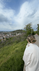 Woman overlooks Plovdiv cityscape from hillside vantage point