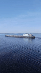 Cargo barge transits Russian waterway near Sheksna under clear skies