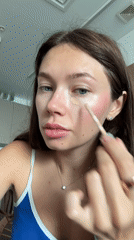 Woman applies makeup during morning routine in Ramat Gan