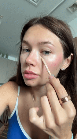 Woman applies makeup during morning routine in Ramat Gan