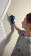 Woman performs wall painting, caulking work in Saint Petersburg