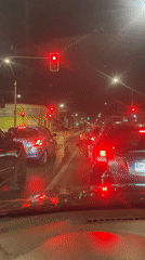 Driver stops at red light as pedestrians cross in Iquique