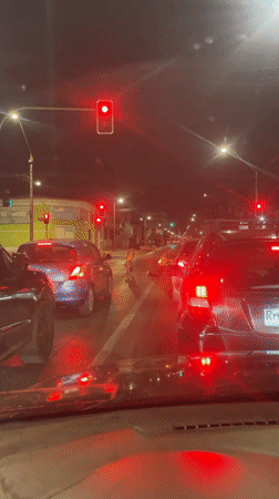Driver stops at red light as pedestrians cross in Iquique