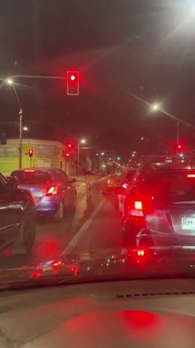 Driver stops at red light as pedestrians cross in Iquique