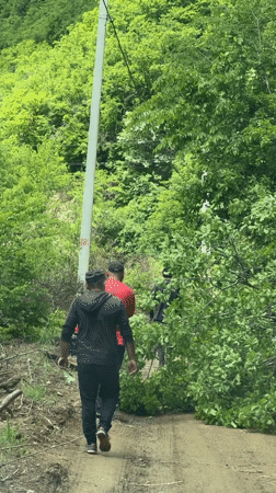 Men clear wooded path debris in Bevreti, Georgia