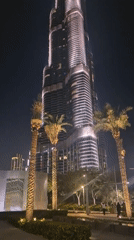 Dubai skyline illuminated at night, multiple towers observed