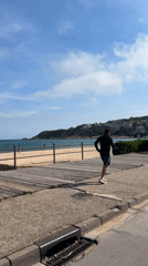 Man runs along beachside walkway in Sant Feliu de Guíxols
