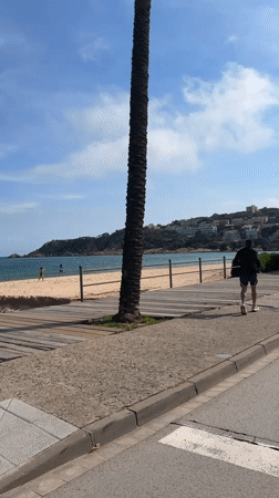 Man runs along beachside walkway in Sant Feliu de Guíxols