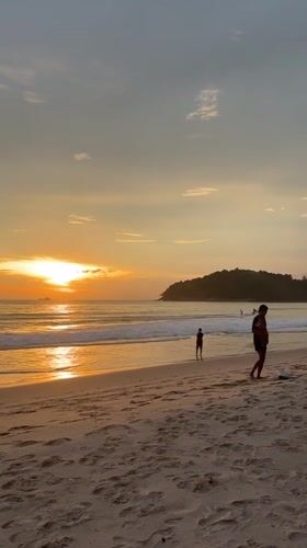 Sunset watchers gather at Thailand beach during golden hour