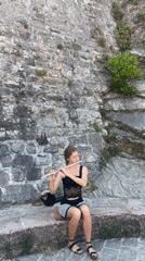 Street musician plays flute in Budva marina district