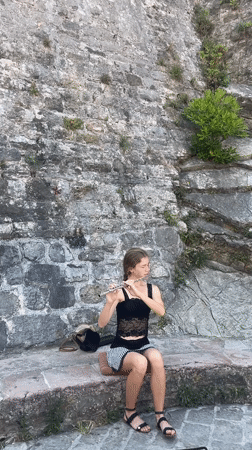 Street musician plays flute in Budva marina district