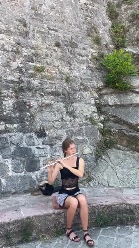 Street musician plays flute in Budva marina district