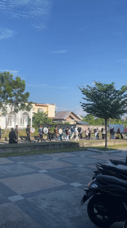 Outdoor parade with flags and drums in coastal Aceh