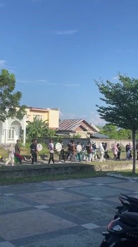 Outdoor parade with flags and drums in coastal Aceh